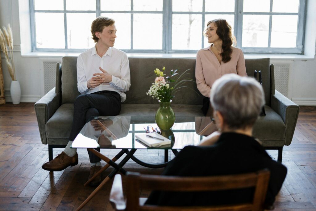 Couple engaged in a therapy session with a counselor in a loft setting.